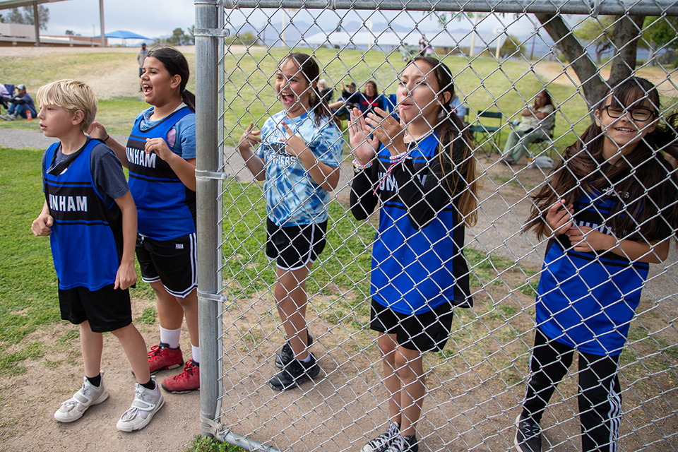 Boys and girls from Dunham cheer on their kickball teammates from the sidelines