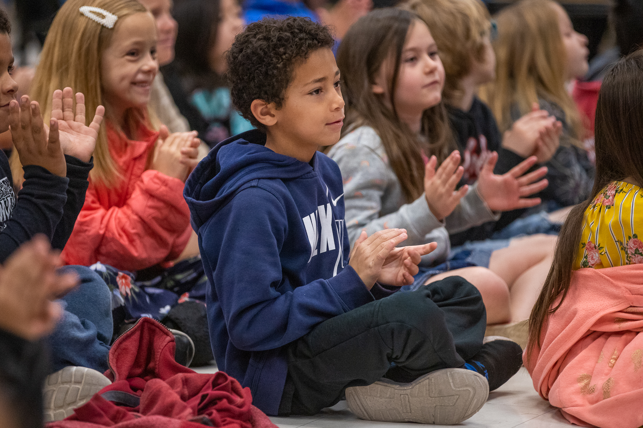 Students clap during a school assembly