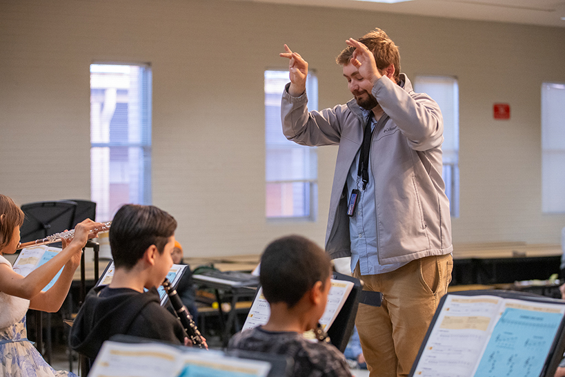 A man directs the student band