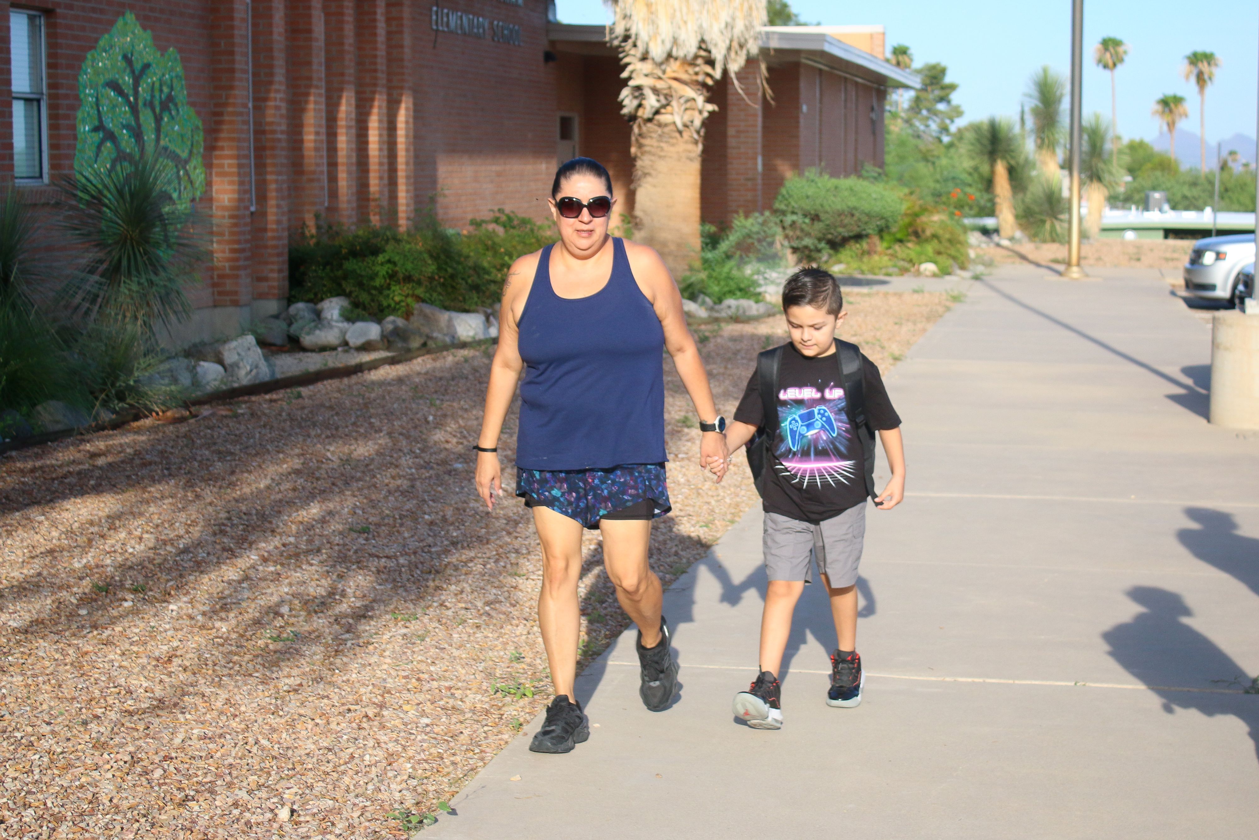 A mom and her son walk into school on the 2nd day