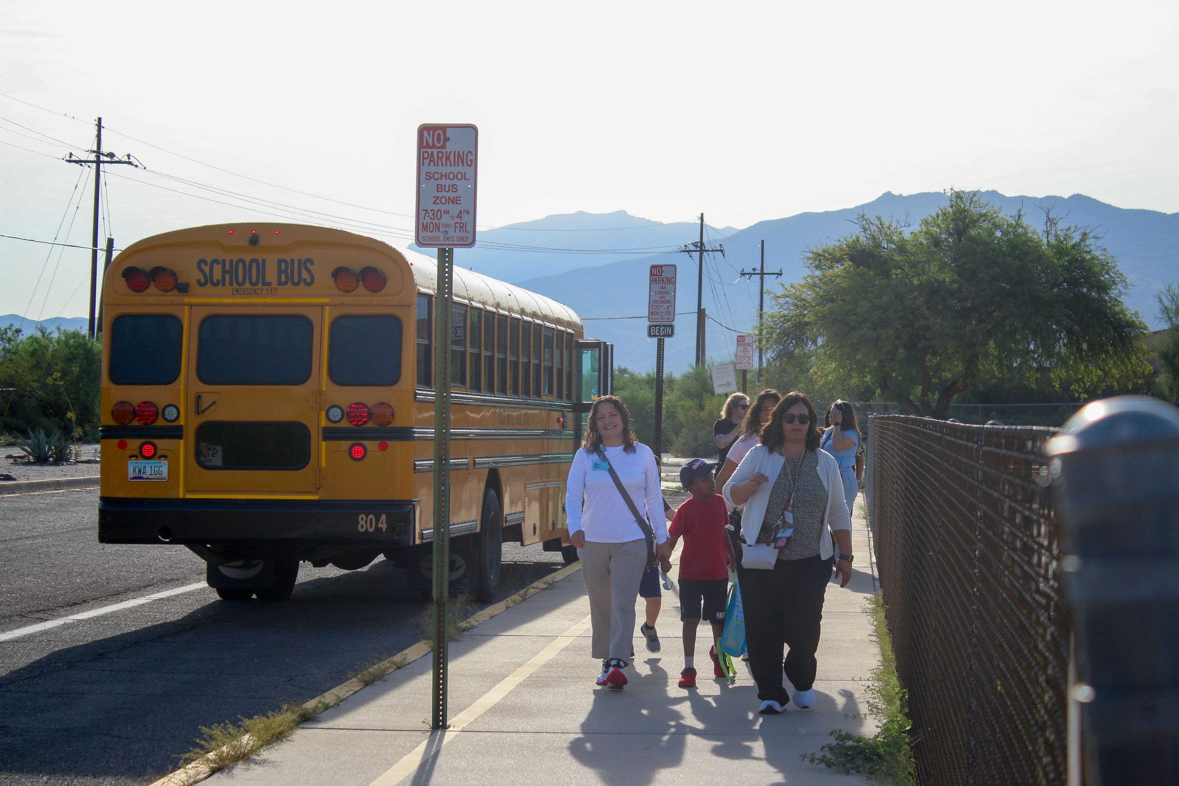 Students and their parents walk away from the school bus